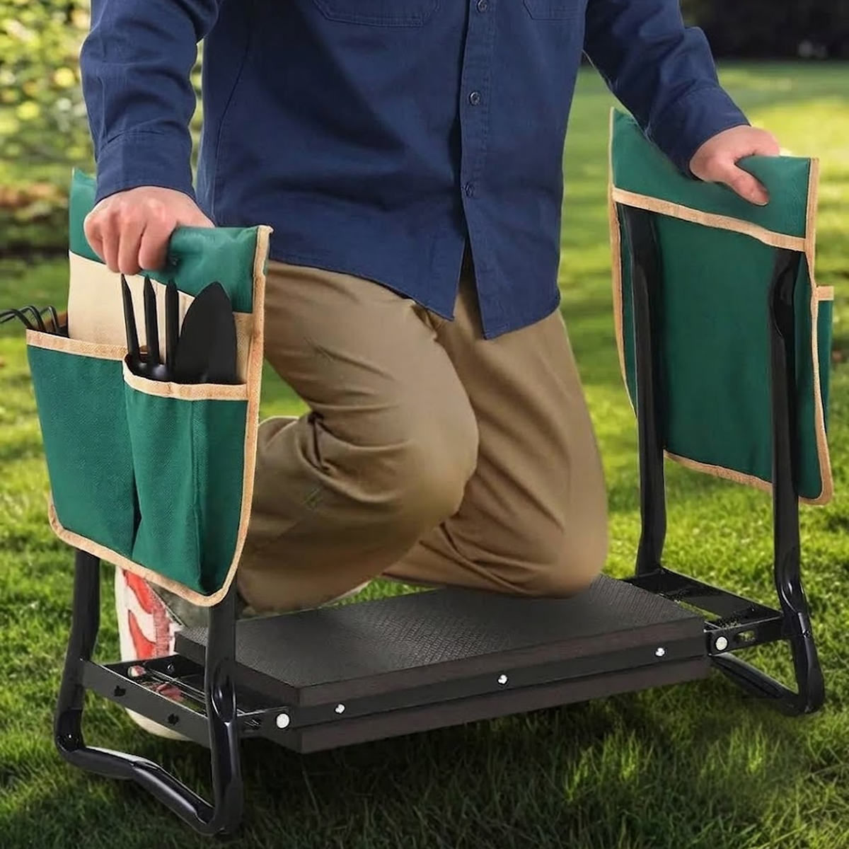 Person using the garden kneeler with both hands on the side rails
